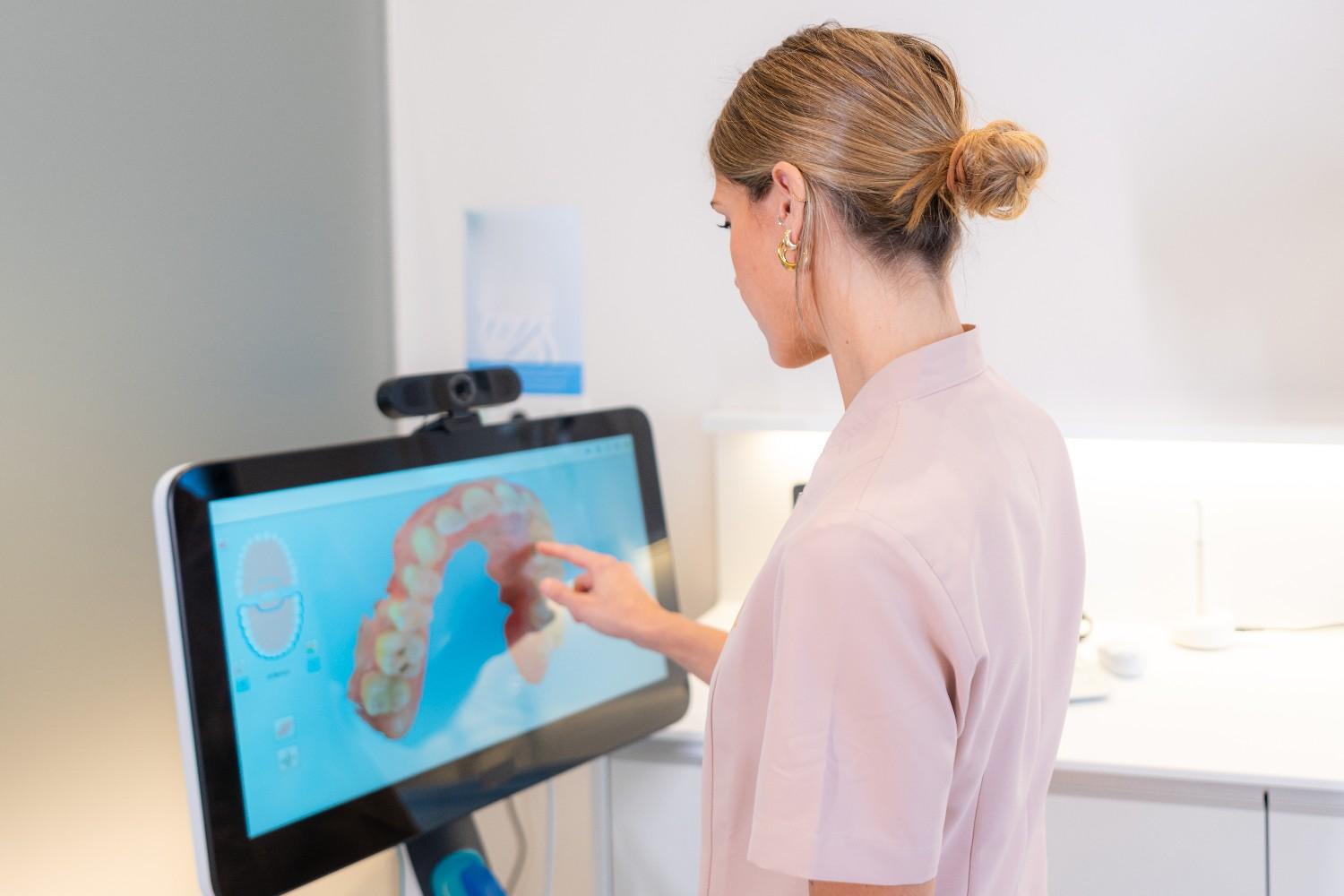 Dentist reviewing 3D dental scan on computer screen